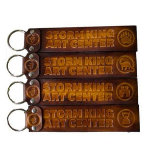 Double-sided leather key chain with dinosaur, hourglass, bear claw or binocular design.