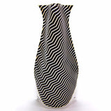 Plastic expandable vase with black and white line pattern.